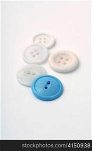 One blue button amongst various white buttons on a white background.