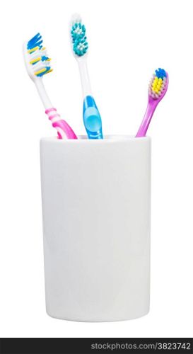 one children and two adult tooth brushes in ceramic glass - family set of toothbrushes isolated on white background