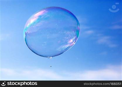 One clean soap bubble flying in the air, blue sky. Sun reflection. One clean soap bubble flying in the air, blue sky.