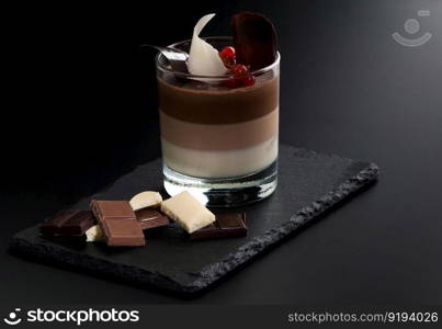one cocktail in a glass with berries and chocolate on the decorative stone on a dark background. one cocktail in a glass with pieces of fruit on the decorative stone on a dark background