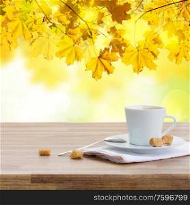 one coffee cup in garden on wooden table. coffee cup in fall garden