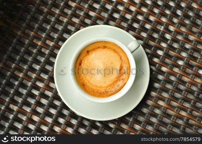 one cup of espresso coffee on rattan brown background