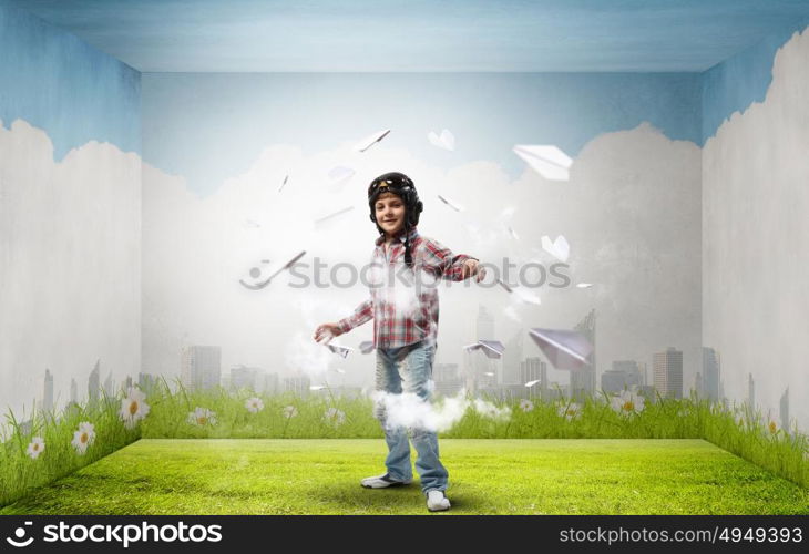 One day I&rsquo;ll become a pilot. Little cute boy in pilot helmet and paper airplanes flying around