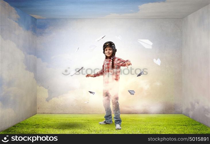 One day I&rsquo;ll become a pilot. Little cute boy in pilot helmet and paper airplanes flying around