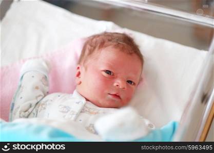 One day old newborn baby in bed