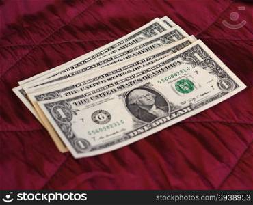 One Dollar notes, United States over red velvet background. One Dollar banknotes money (USD), currency of United States over crimson red velvet background