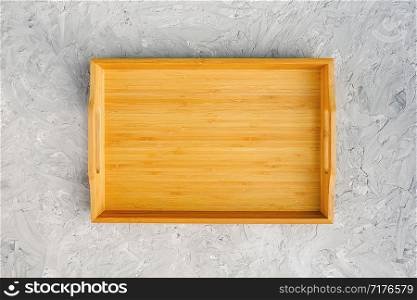 One empty wooden tray on gray stone table. Top view Mock up.. One empty wooden tray on gray stone table. Top view Mock up