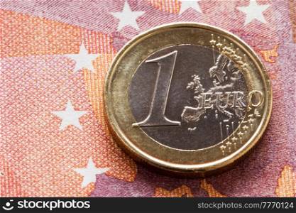 One Euro coin on ten Euros background