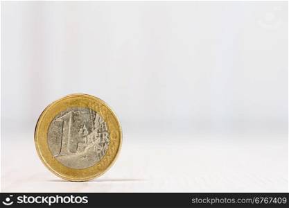 One euro coin on white wood background. With copy-space for text