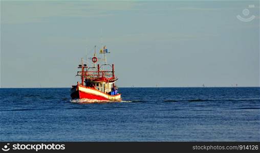 One fisherman boat in a sea blue sky background