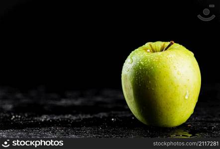 One fresh green apple on the table. On a black background. High quality photo. One fresh green apple on the table.