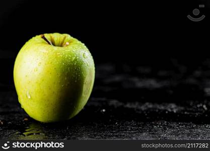 One fresh green apple on the table. On a black background. High quality photo. One fresh green apple on the table.