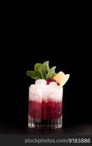 one glass cup with pomegranate drink and ice on a dark background. beverages on a dark background