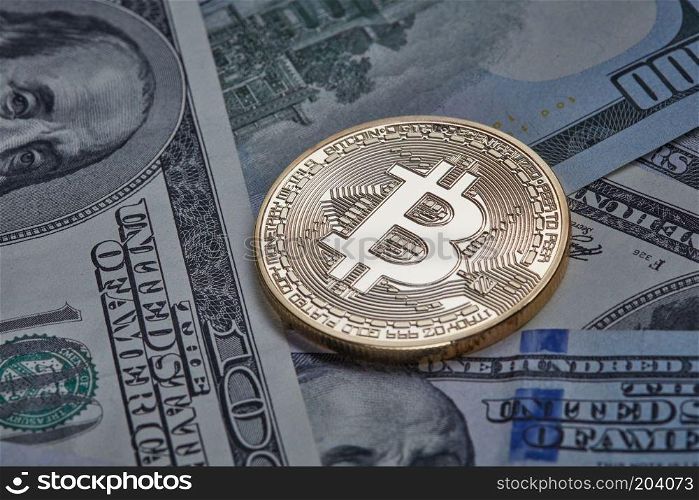 One gold coin in the background of dollar bills. Conceptual image for worldwide cryptocurrency and digital payment system.. One gold coin in the background of dollar bills