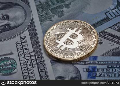 One gold coin in the background of dollar bills. Conceptual image for worldwide cryptocurrency and digital payment system.. One gold coin in the background of dollar bills