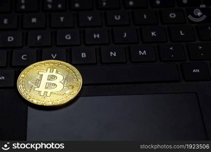 One golden bitcoin on dark black keyboard of computer, crypto currency,trading and technology concept with copy space pc. One golden bitcoin on dark black keyboard of computer, crypto currency,trading and technology concept with copy space