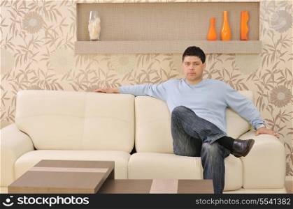 one happy young man relax at home in livingroom with modern style furniture indoor