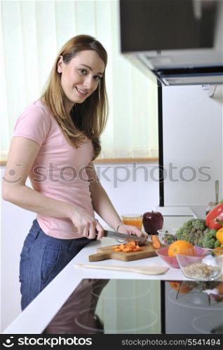 one happy young woman with apple in kitchen and other food and vegetables