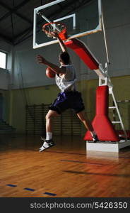 one healthy young man play basketball game in school gym indoor