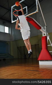 one healthy young man play basketball game in school gym indoor