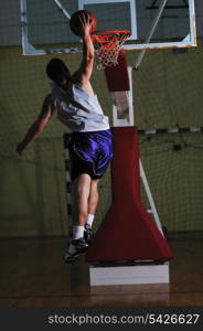 one healthy young man play basketball game in school gym indoor