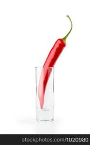 One hot red chili pepper in a vodka glass, isolated on white background
