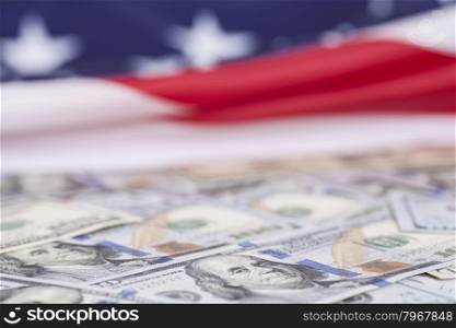 One hundred dollar bills on American flag background