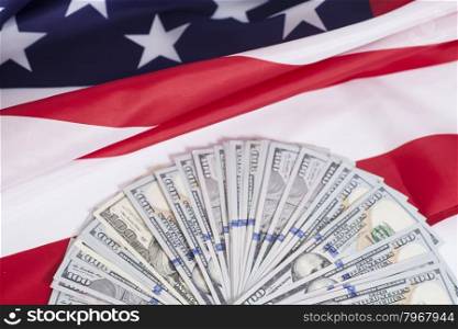 One hundred dollar bills with American flag background