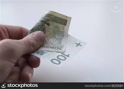 One hundred Polish zloty banknotes in hand