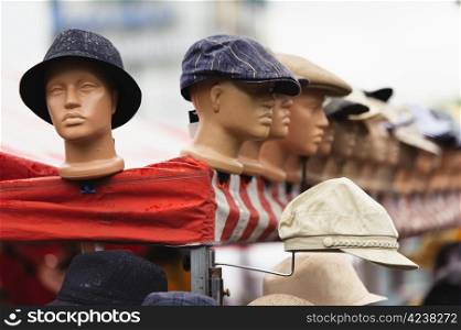 One is out of the group, plastic model heads with the hats in the outdoors market.