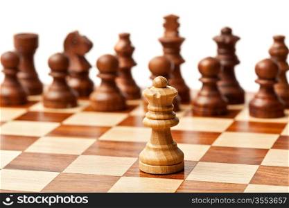 One king agains all - wooden chess pieces on chessboard. Selective focus, shallow depth of field