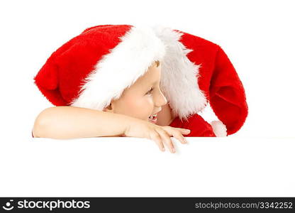 One little boy in a cap of santa whispers another something over the blank banner, isolated