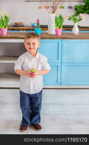One little cute boy with easter eggs in the kitchen. Happy easter.. One little cute boy with easter eggs in the kitchen.