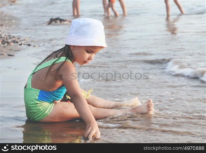 One Little Cute Pensive Girl Playing On A Sand Beach