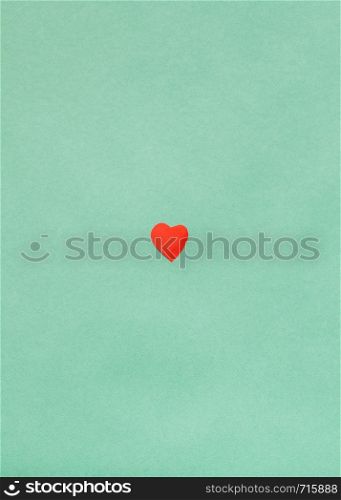 one little heart cut out of red paper on background from Dark Sea Green pastel paper