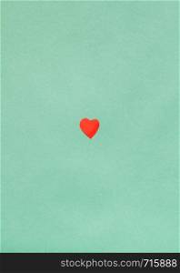 one little heart cut out of red paper on background from Dark Sea Green pastel paper
