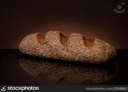 one loaf of bread close-up on a dark background with reflection. bread on a dark background
