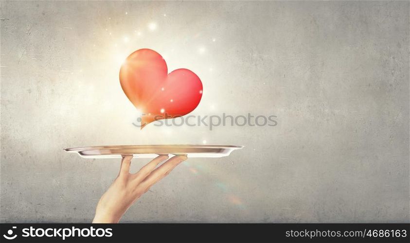 One love. Human hand holding tray with red heart on it