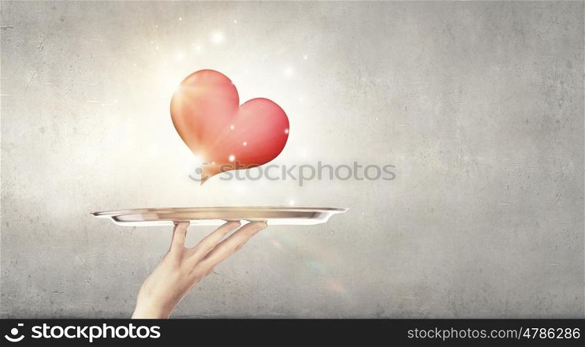 One love. Human hand holding tray with red heart on it