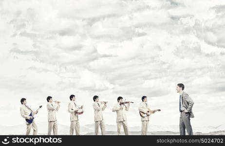 One man band. Man orchestra in suit playing different music instruments