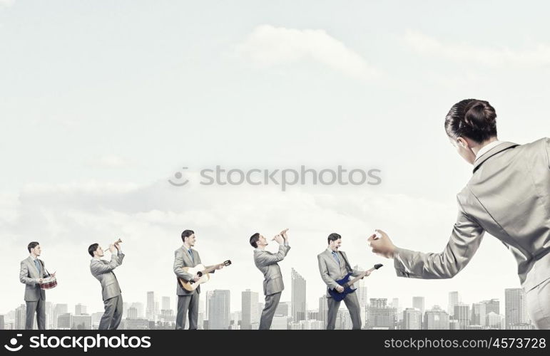 One man band. Man orchestra playing different music instruments and woman leader