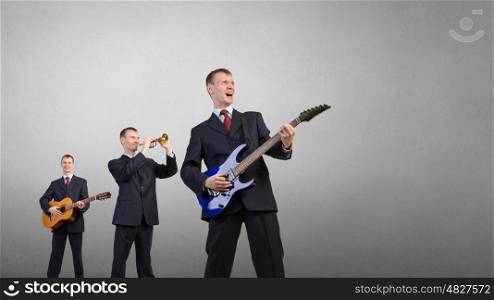 One man band. Young man in suit and people playing different music instruments