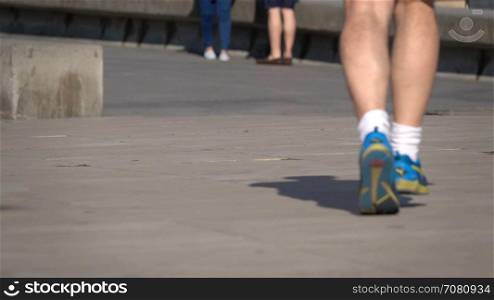 One man runs on a city sidewalk