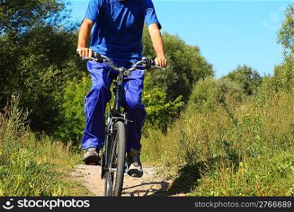 one man wearing sporty clothes is riding on a bycicle. body of man. sunny summer day.
