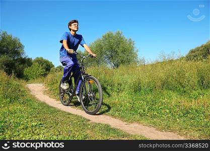 one man wearing sporty clothes is riding on bycicle. sunny summer day. wide angle.