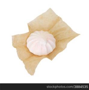 One meringue in the packaging paper isolated on white background