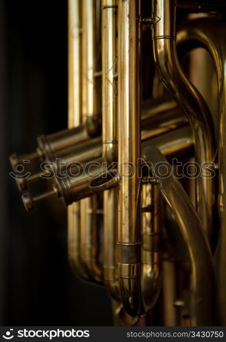One or more brass musical instruments on display in a store window.Note that this photograph has shallow depth of field on the closest element.