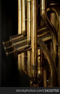 One or more brass musical instruments on display in a store window.Note that this photograph has shallow depth of field on the closest element.