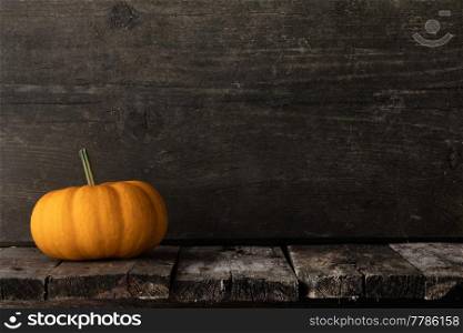 One orange pumpkin on dark wooden background, Halloween concept. Pumpkin on wooden background