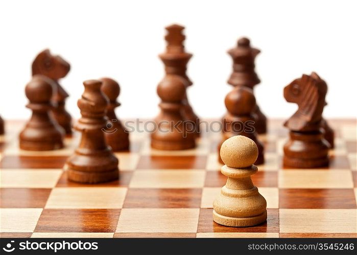 One pawn agains all - wooden chess pieces on chessboard. Selective focus, shallow depth of field